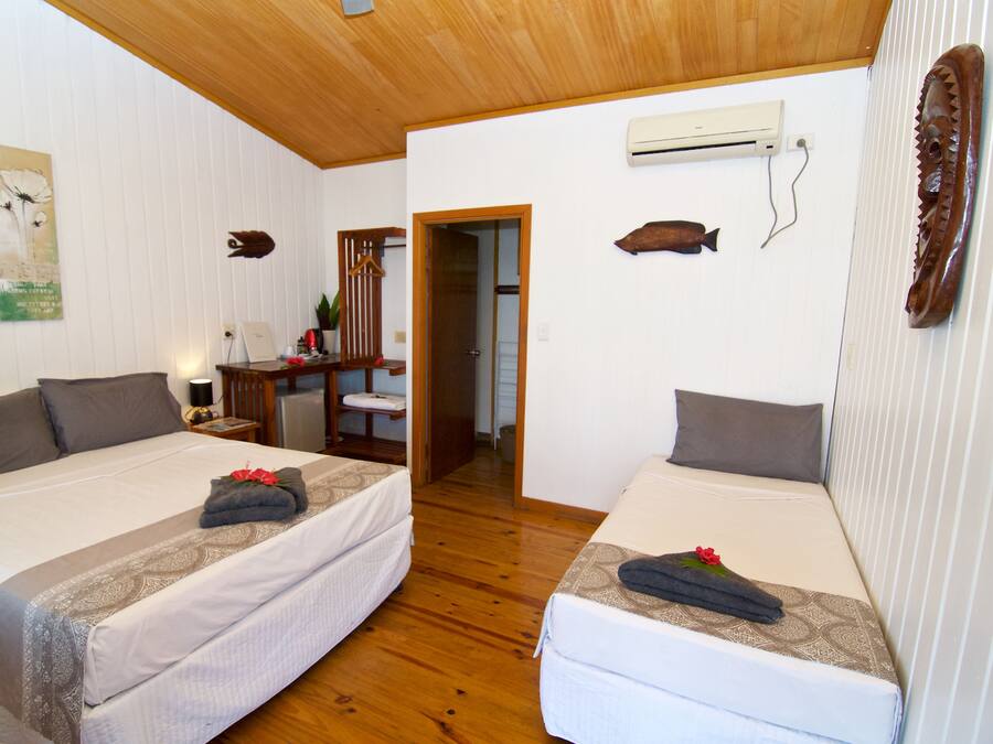 Une chambre d’hôtel avec deux lits, un plancher en bois et un plafond en bois.