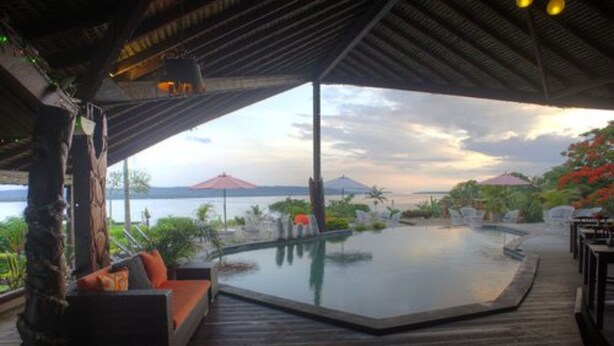 A covered outdoor area with a pool, seating, and a view of the water. - Deco Stop Lodge (Luganville)
