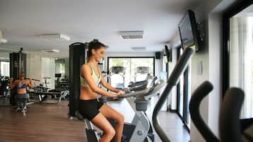 A gym with exercise equipment, a treadmill, and a mirror.