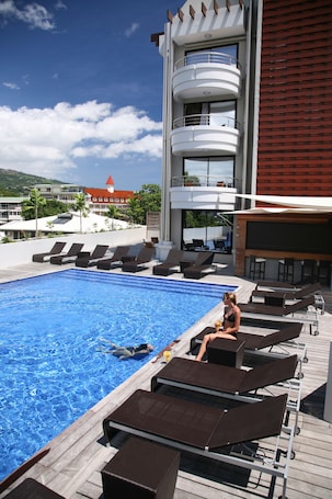 A pool area with lounge chairs and a pool.