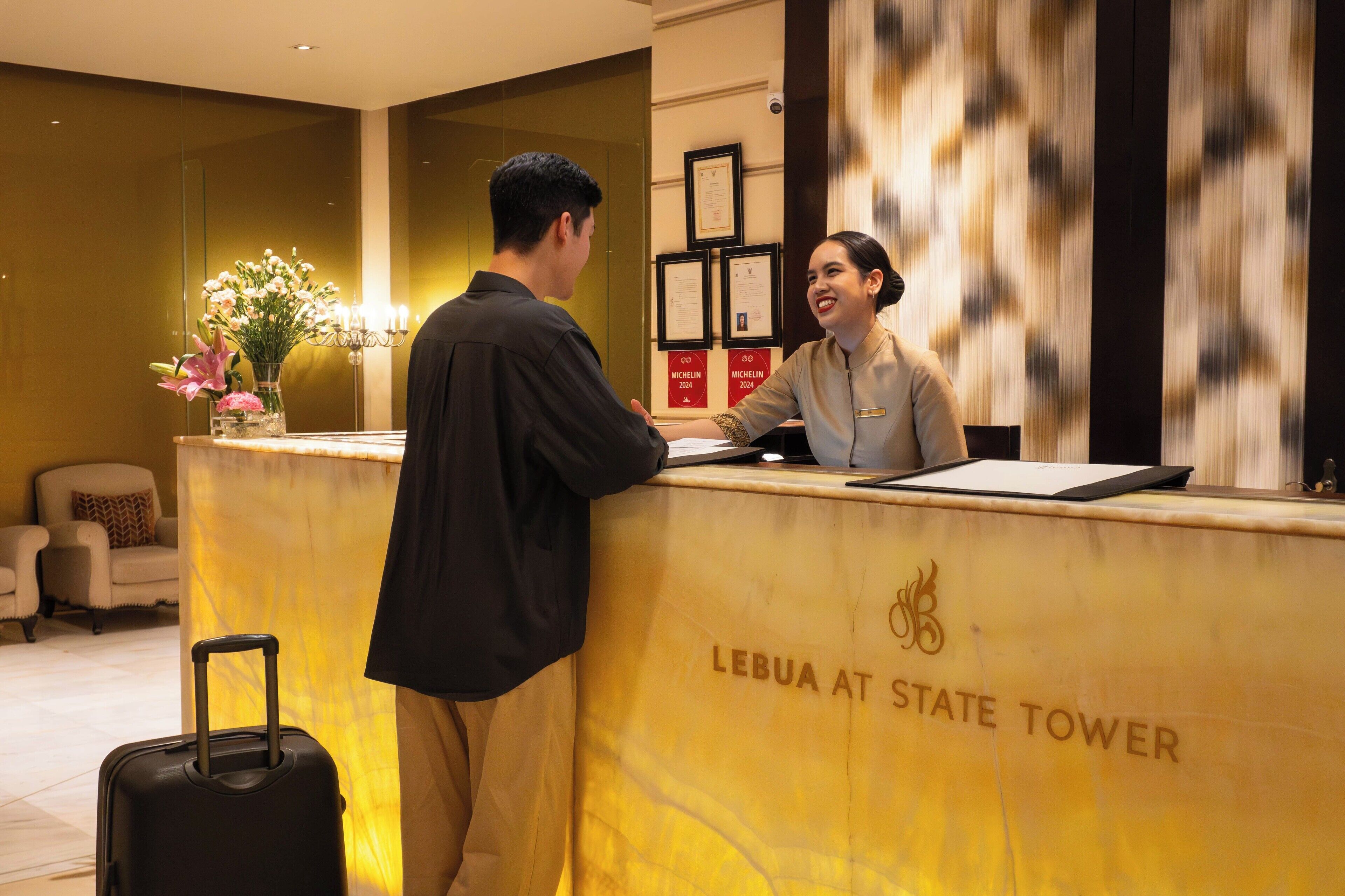A reception desk at Lebua at State Tower with a man and a woman interacting.