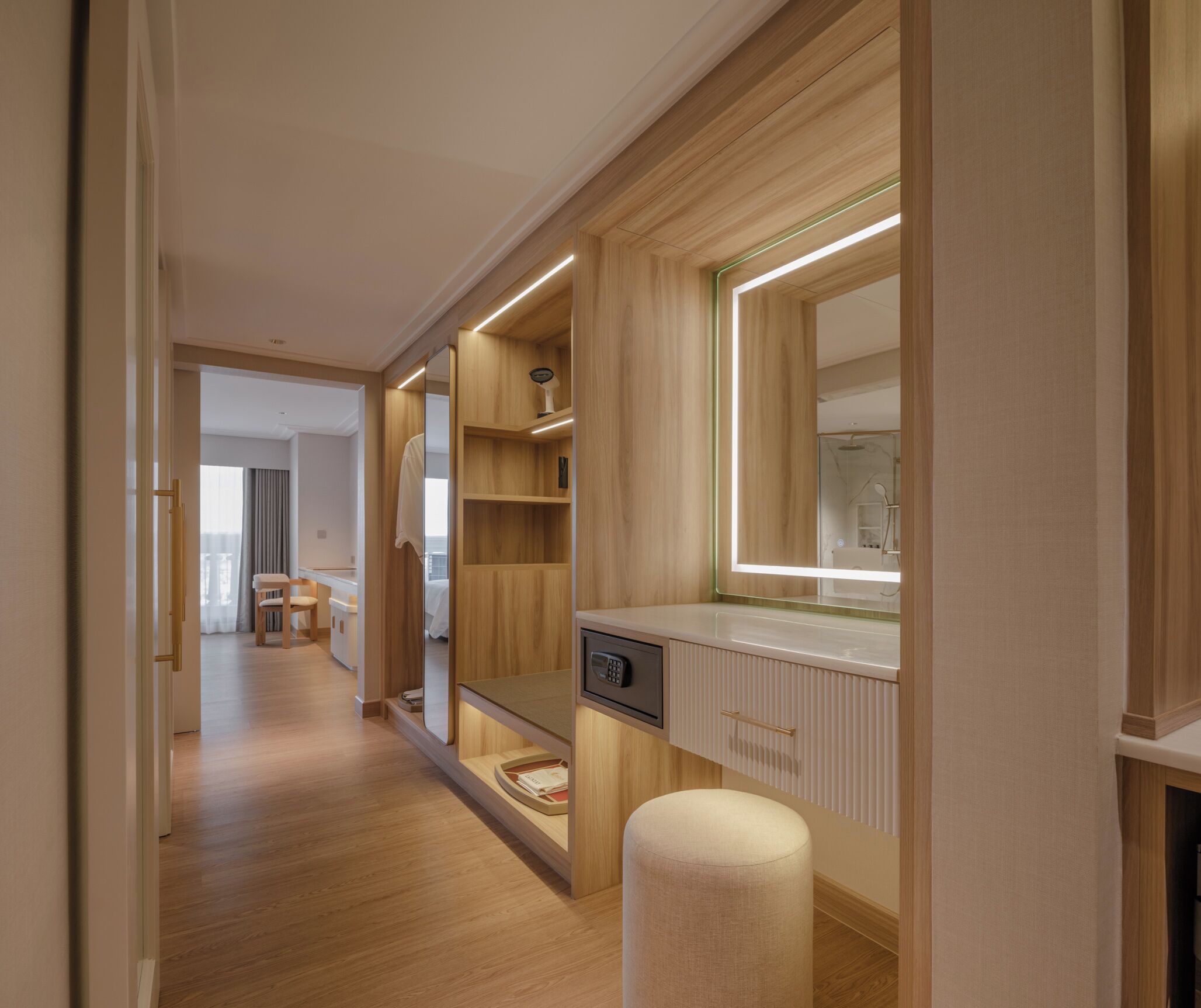 A hallway with wooden flooring, a mirror, a radiator, and a small stool.