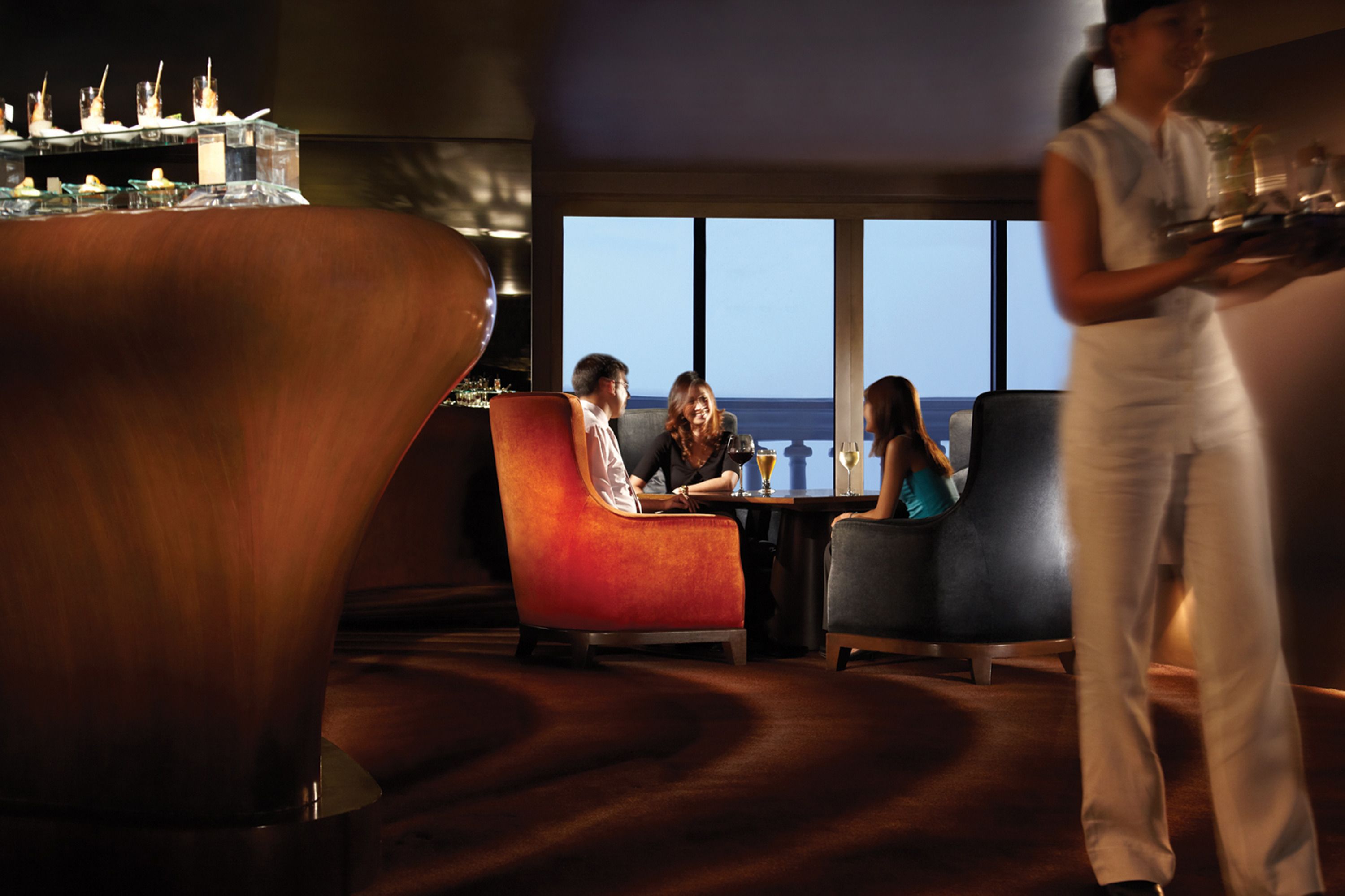Ein stilvoller Lounge-Bereich mit Meerblick, bequemen Sitzgelegenheiten und einer Bar.