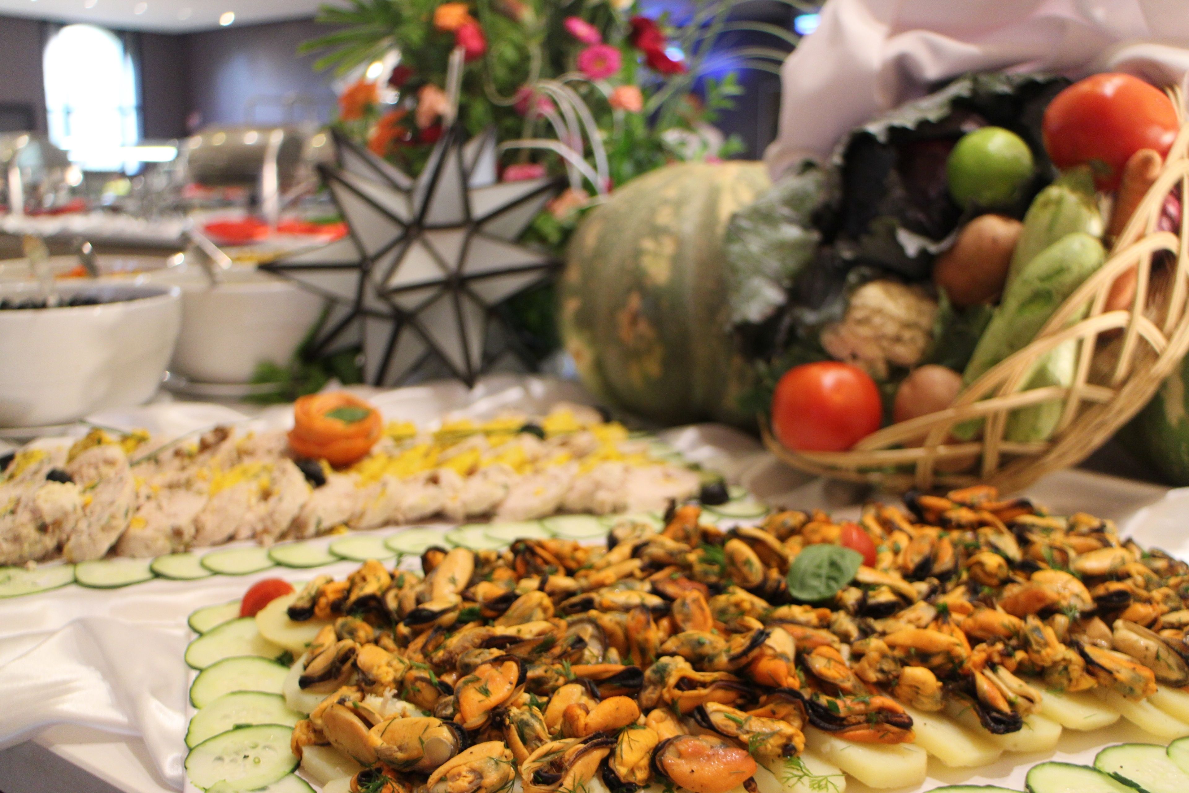 Une table de buffet proposant des fruits de mer, des légumes et une étoile décorative.