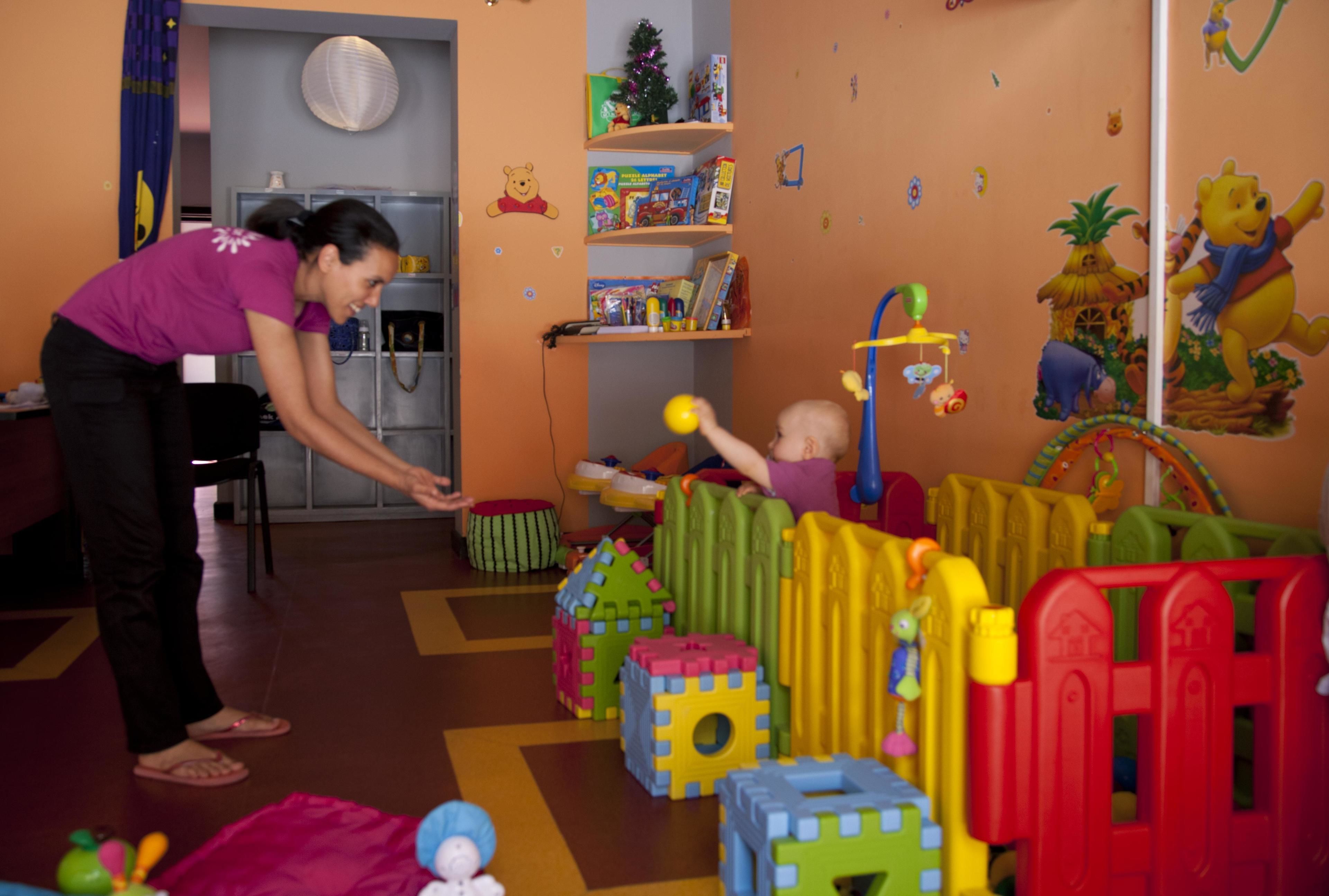 A play area with colorful building blocks and a child playing.