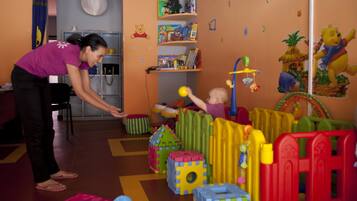 A play area with colorful building blocks and a child playing.
