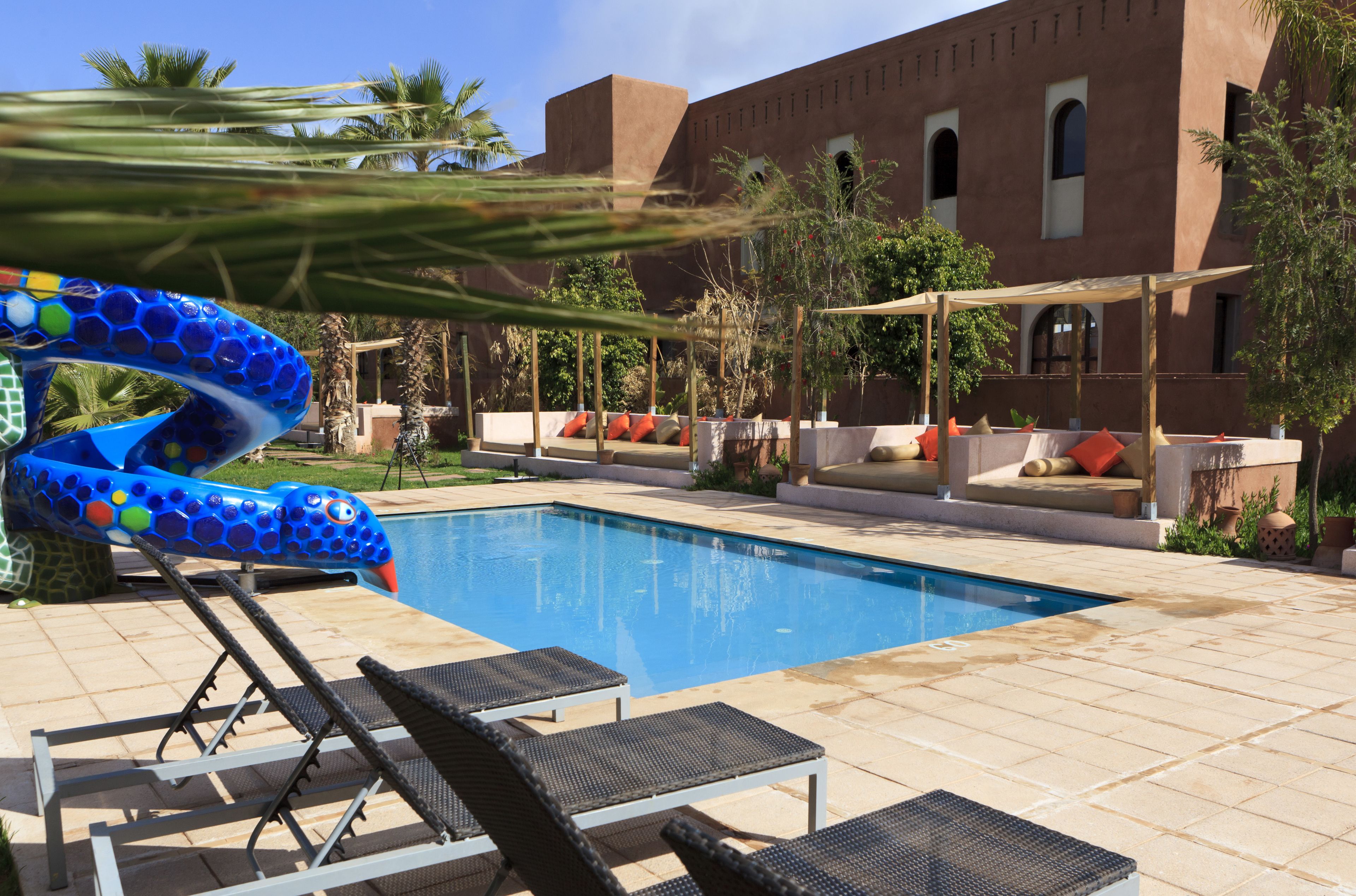 A swimming pool with lounge chairs and a decorative blue sculpture.