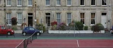 A tennis court with a building in the background.
