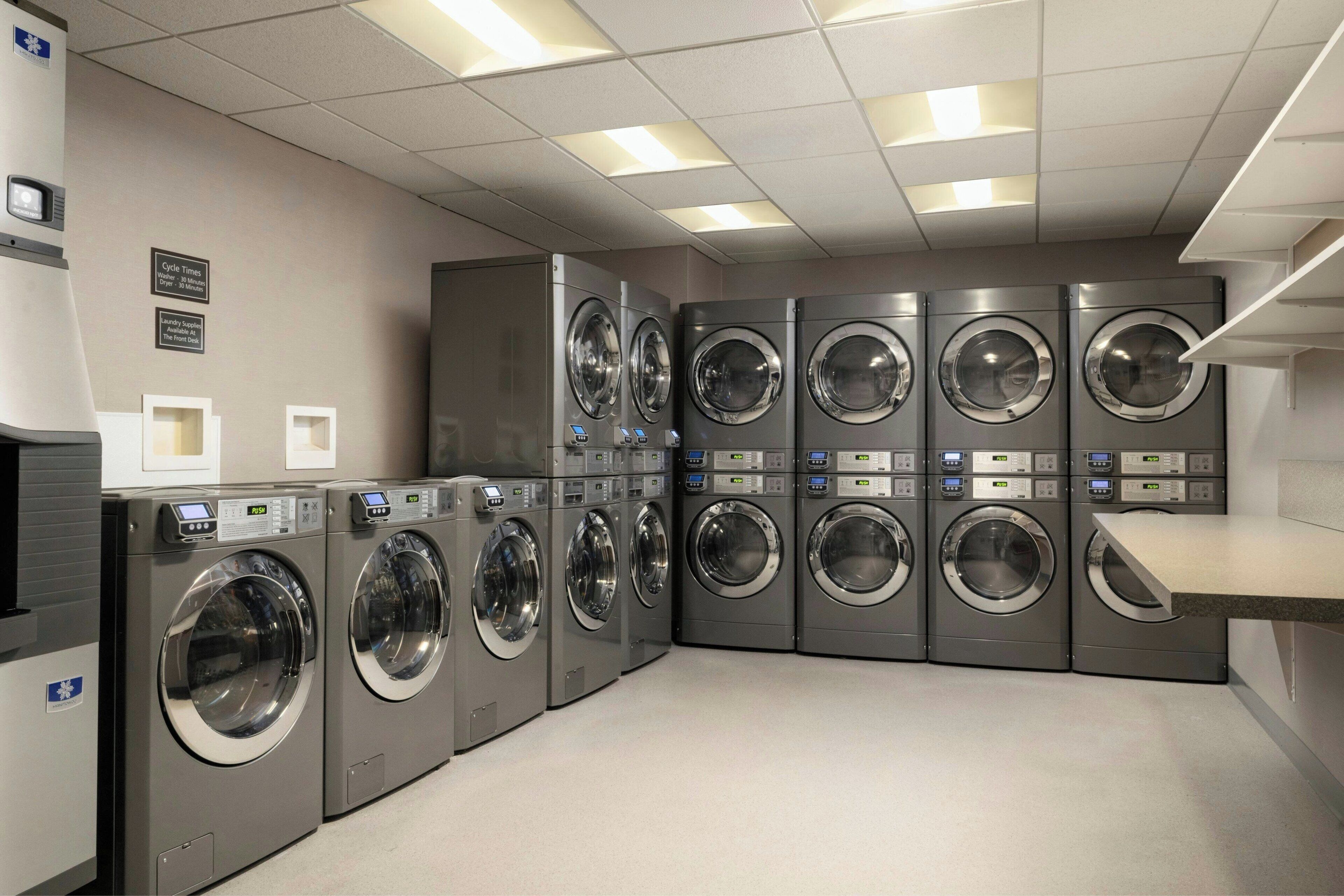 A laundry facility with multiple washing machines arranged in rows.