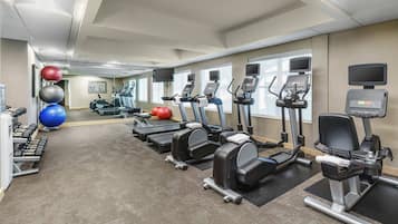 A gym with treadmills, elliptical machines, and free weights.