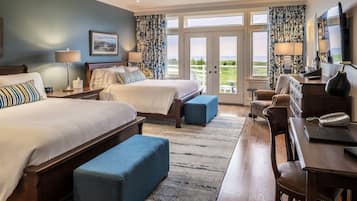 Een hotelkamer met twee bedden, een bureau, een stoel, een telefoon en uitzicht op het omliggende landschap.