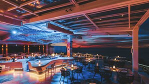 An outdoor dining area with tables and chairs, a bar, and a view of the sky. - Crimson Resort and Spa Mactan (Lapu-Lapu)