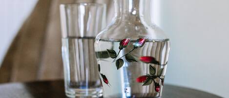 Two clear glass vases with floral designs on a wooden surface.