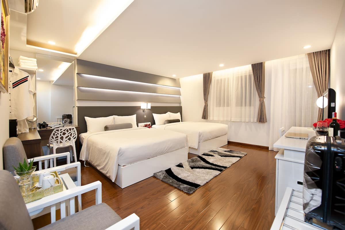 Une chambre d’hôtel moderne, dotée d’un grand lit, d’un bureau et d’un coin salon.