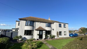 A two-story house with a tiled roof, a front entrance, and a small garden. - Waterside Guest House (Romney Marsh)