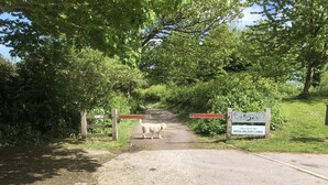 A gate with a sign welcoming visitors to the Royal Military Canal, surrounded by lush greenery. - Waterside Guest House (Romney Marsh)