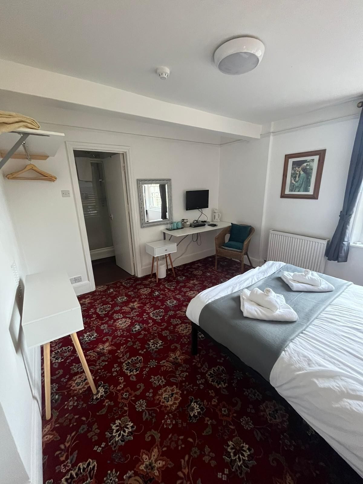 Une chambre d’hôtel équipée d’un lit, d’un bureau, d’une armoire et d’un radiateur.