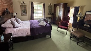 A bedroom with a bed, a chair, a desk, and a window. - The Boot Inn (Worcester)