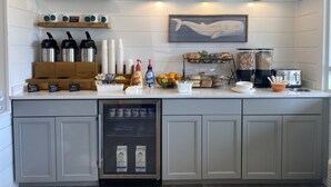 A kitchen counter with coffee-making equipment, a refrigerator, and a coffee machine. - The Shore House (Ocean City)