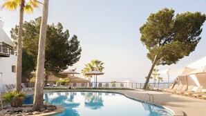 A swimming pool with lounge chairs and palm trees. - Ona Aucanada Club (Alcúdia)