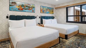 A hotel room with two beds, a large window, and two paintings on the wall.