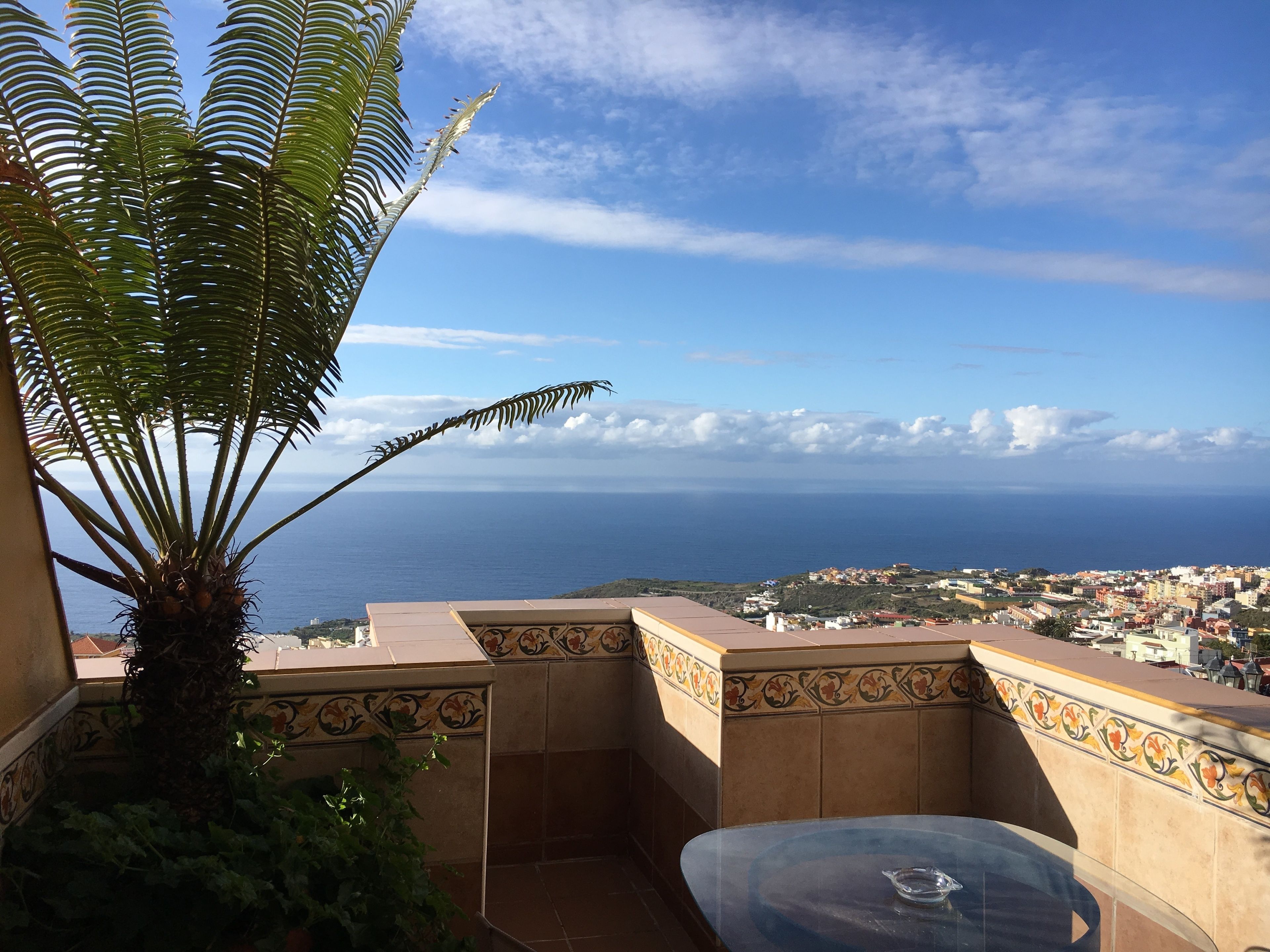 A balcony with a view of the sea and a town.