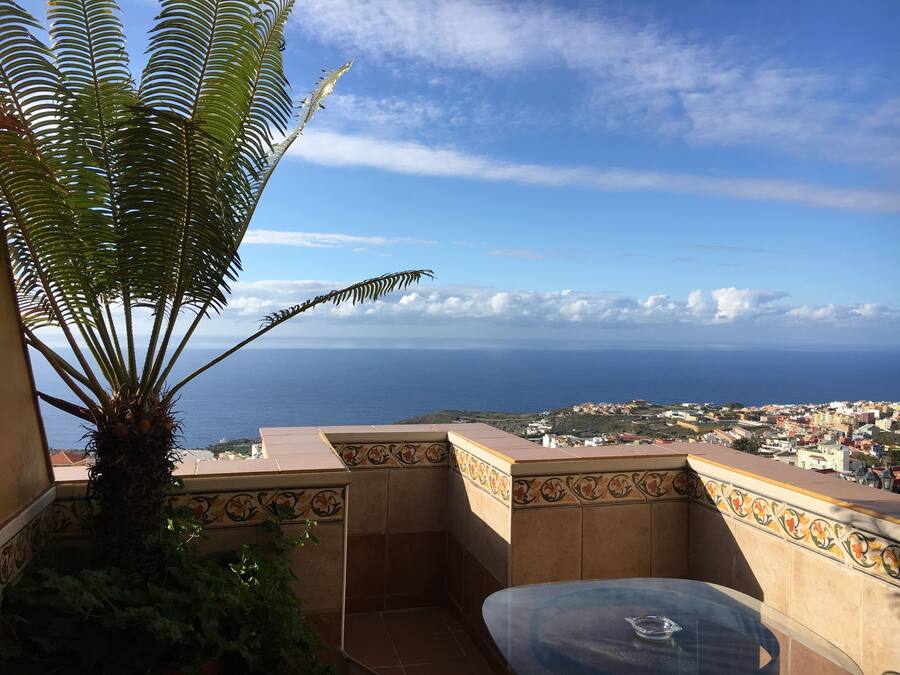 A balcony with a view of the sea and a town.