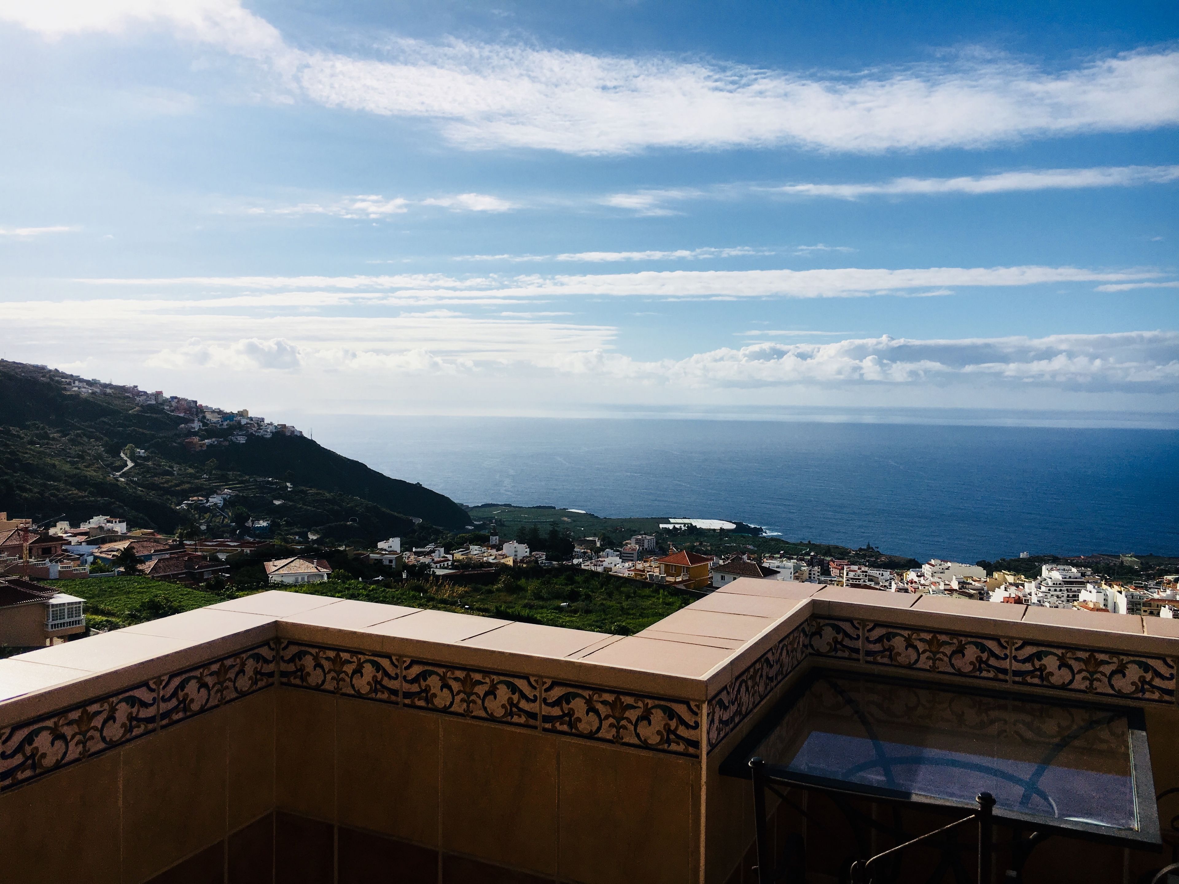A coastal town with a view of the sea and a hilly landscape.