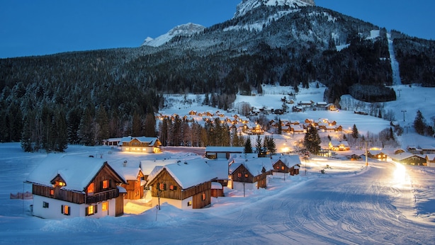 A snow-covered village with wooden houses and a mountain in the background. - AlpenParks Hagan Lodge Altaussee (Altaussee)
