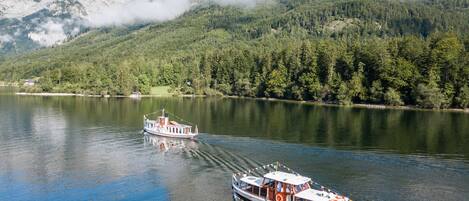 A boat on a calm lake with a mountainous backdrop.