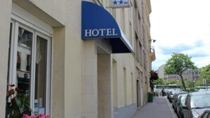 A hotel building with a sign that reads "HOTEL" and a smaller sign below it. - Hotel Neptune (Paris)