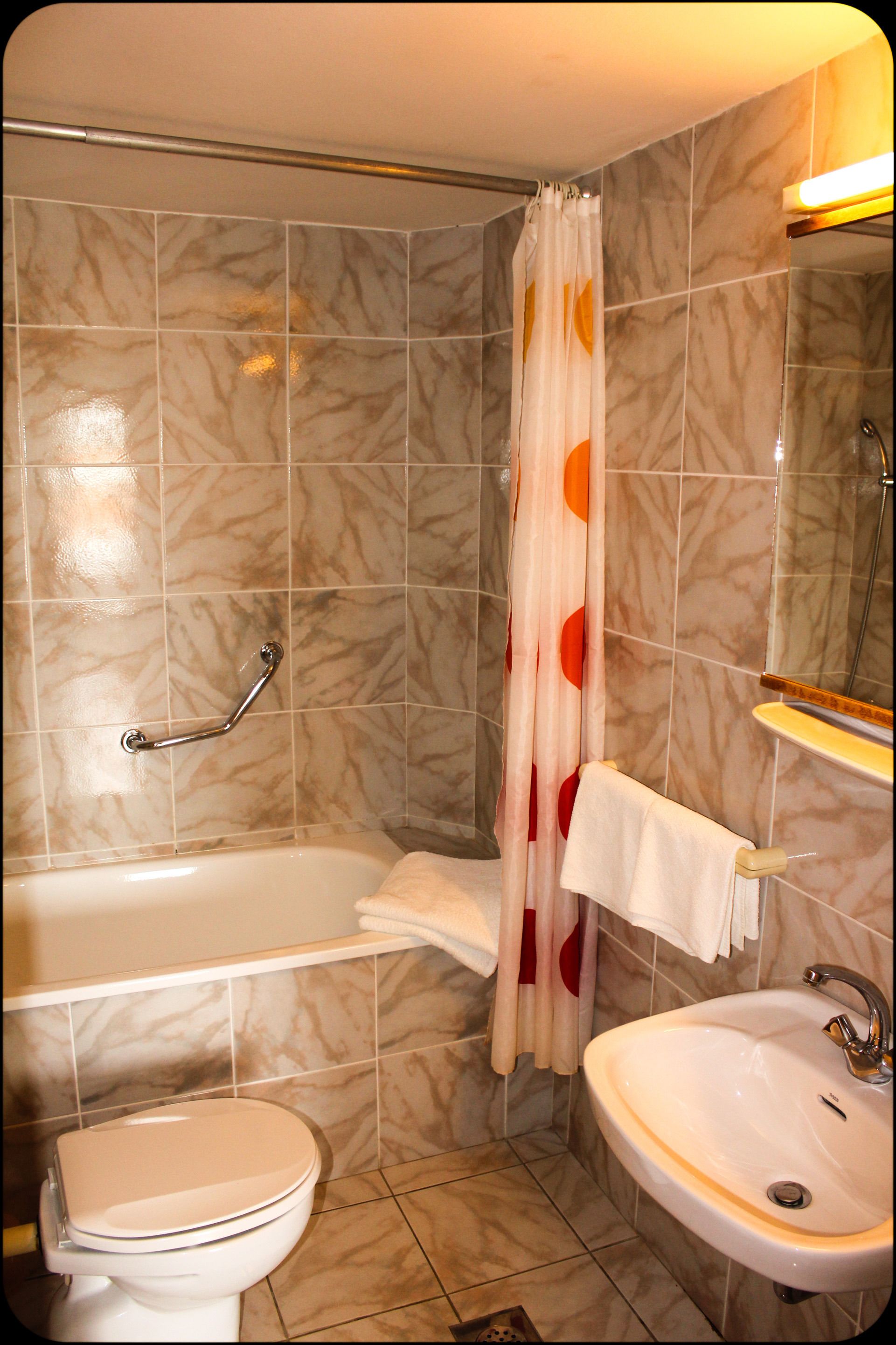 Un baño con bañera, inodoro y lavabo.