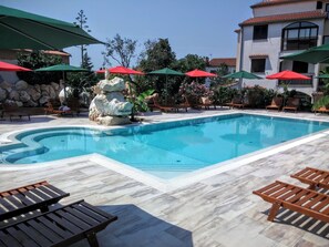 Utomhuspool, parasoller och solstolar