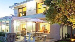 A modern house with a patio area featuring outdoor furniture and a fire pit.