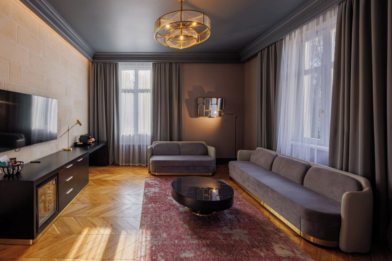 Una sala de estar moderna con un sofá, una mesa de centro y un televisor sobre un mueble.