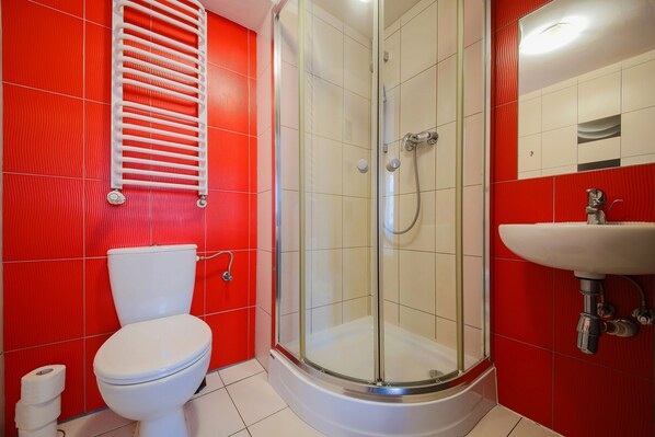 A bathroom with a glass-enclosed shower, a white toilet, and a sink. - Boogie Deluxe Old Town (Wroclaw)
