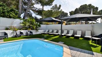 Een seizoensgebonden buitenzwembad, parasols voor strand/zwembad