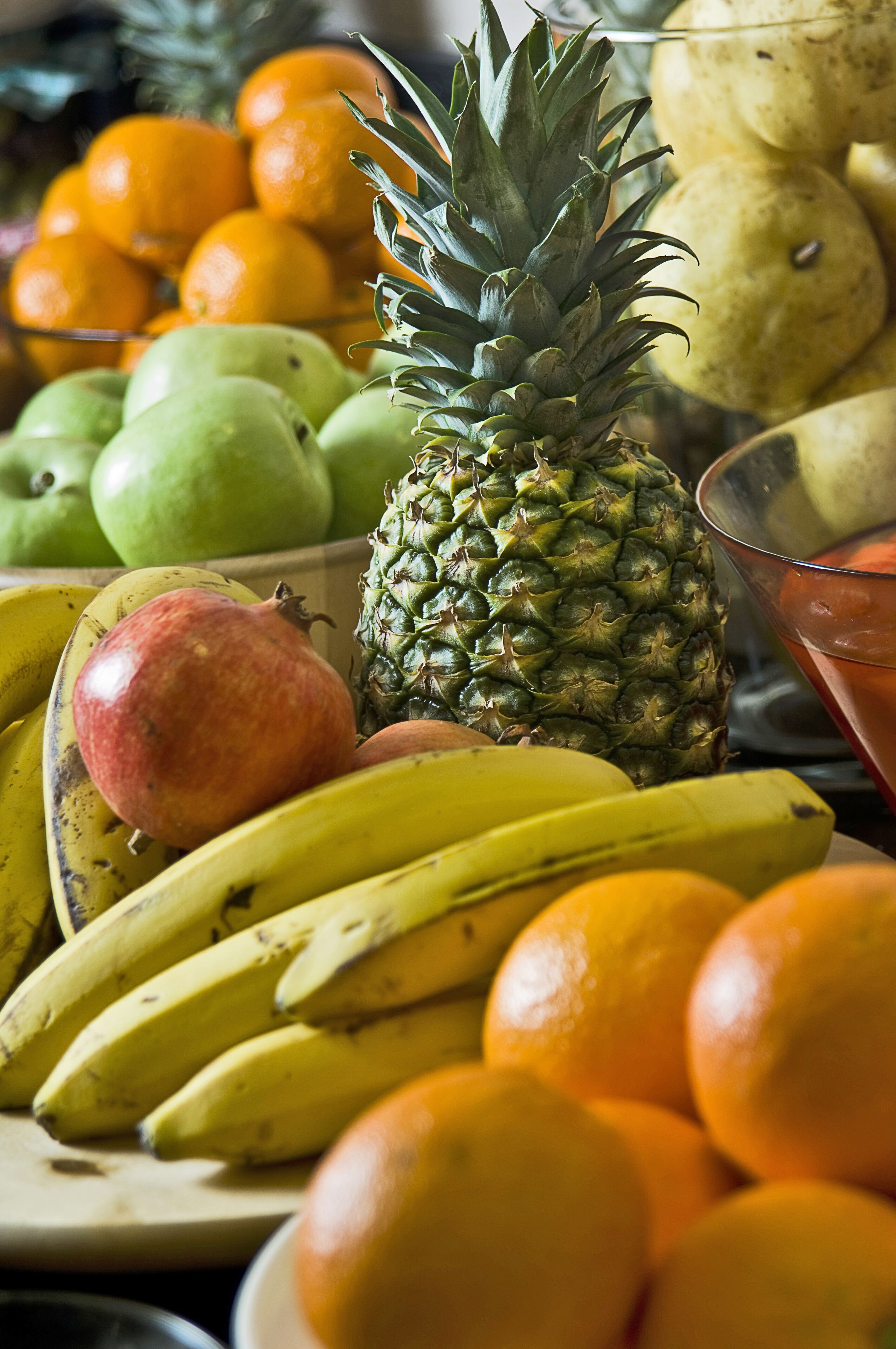 Une variété de fruits, notamment des bananes, des oranges et un ananas.