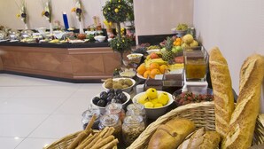A buffet with various breads, fruits, and beverages. - Tugcu Hotel Select (Bursa)