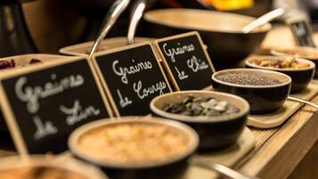 A buffet with various dishes labeled in French, including 'Grains de Lin' and 'Graine de Chia'.