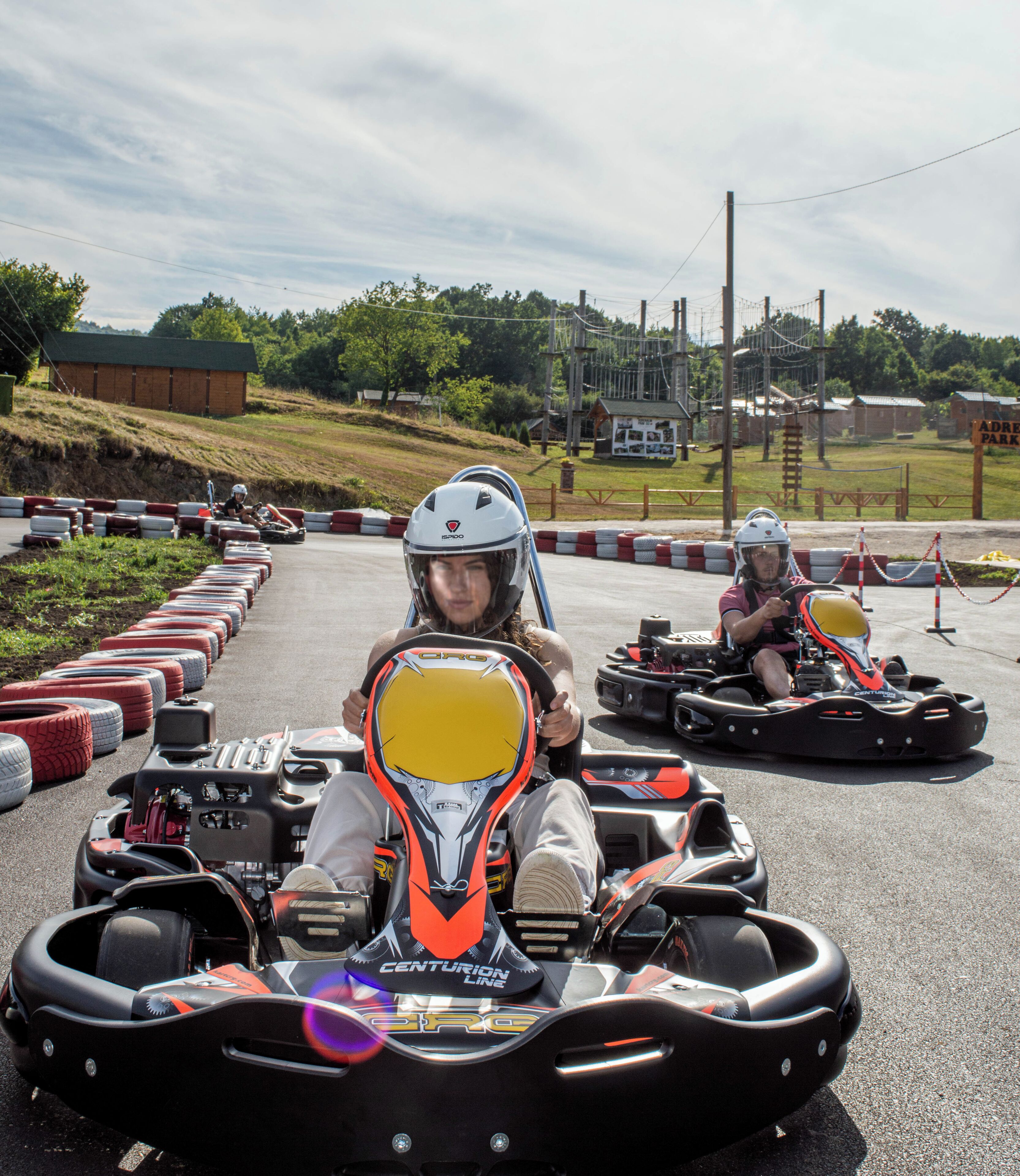 Kart de corrida em pista, com barreiras de segurança e área gramada ao fundo.