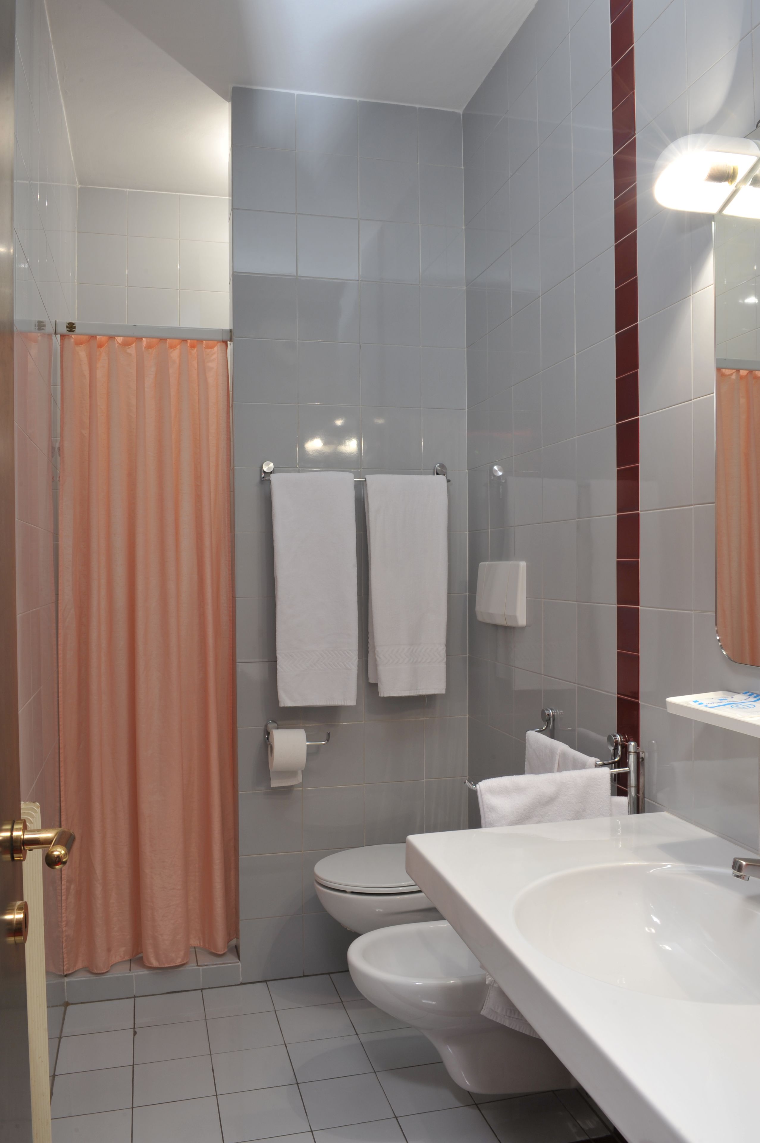 A modern bathroom with a shower, toilet, and sink.