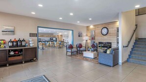 A spacious hotel lobby with a seating area, a kitchen, and a staircase. - Country Inn & Suites by Radisson, St. Peters, MO (St. Charles)