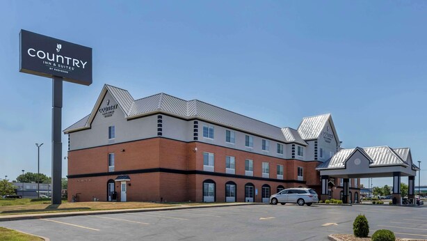 A Country Inn & Suites building with a brick facade, multiple windows, and a covered parking area.