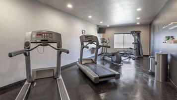 A gym with treadmills, a stationary bike, and a weight machine.