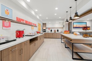 A modern kitchen with a breakfast bar, a red coffee maker, and a sign for special dietary needs.