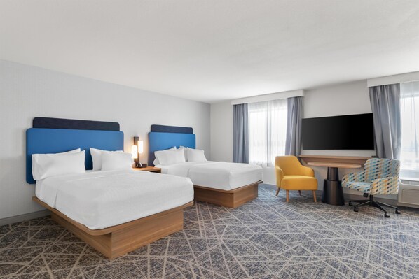 A hotel room with two beds, a desk, a TV, and a patterned carpet. - Hampton Inn & Suites New Castle (New Castle)