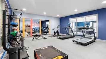 A gym with treadmills, a bench, and weightlifting equipment.