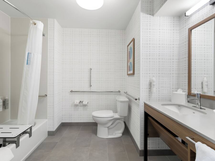 A modern bathroom with a bathtub, toilet, and sink.