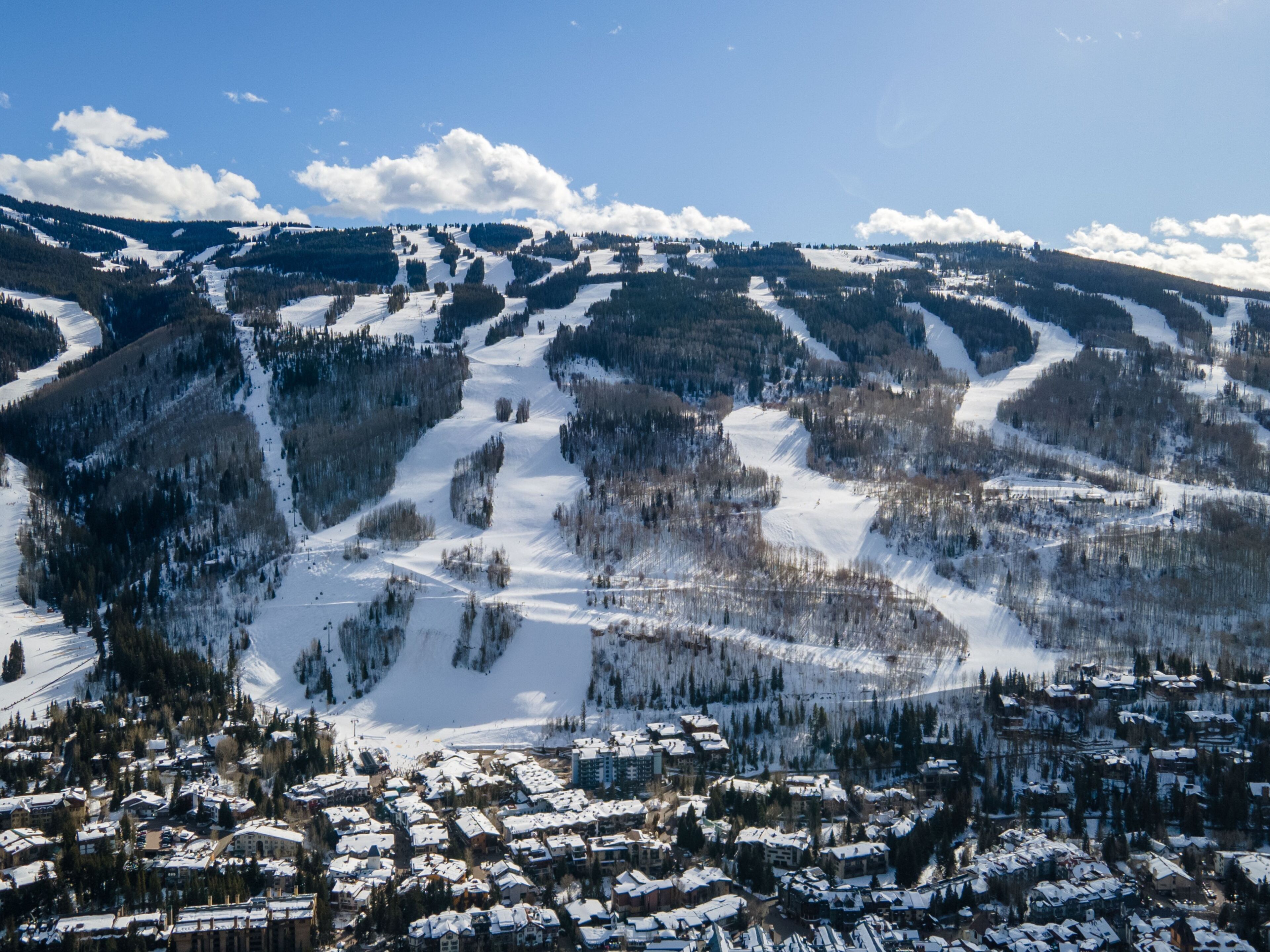 A snow-covered mountain with ski slopes and a town at the base.
